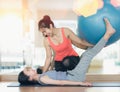 Asian woman fitness coach teach her student for rubber ball exercise