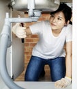 Asian woman fixing kitchen sink