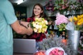 Asian Woman Florist Small Business Flower Shop Owner and She is using her telephone and laptop to take orders for her store Royalty Free Stock Photo