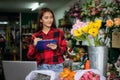 Asian Woman Florist Small Business Flower Shop Owner working and Holding A Clipboard  Writing to take orders for her store Royalty Free Stock Photo