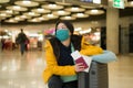 Asian woman flying in covid19 times - lifestyle portrait of young beautiful and tired Korean girl in face mask waiting on airport Royalty Free Stock Photo