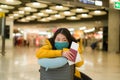 Asian woman flying in covid19 times - lifestyle portrait of young beautiful and tired Korean girl in face mask waiting on airport Royalty Free Stock Photo