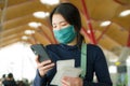 Asian woman flying in covid19 times - lifestyle portrait of young tired and attractive Korean girl in face mask waiting on airport Royalty Free Stock Photo