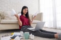 Asian woman freelancer stress emotion while working with laptop and paperwork at sofa in living room in house.work at home concept Royalty Free Stock Photo