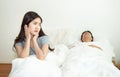 Asian woman getting disturbed and annoy with man sleep and snoring on bed. Bedroom, authentic