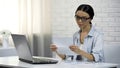 Asian woman in glasses reading letter, subpoena, receipt of correspondence