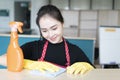 Asian woman in gloves cleaning with cleanser spray at home or office, house cleaning service or housekeeping concept Royalty Free Stock Photo