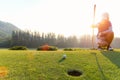 Asian Woman golf player crouching and study the green before putting shot. Royalty Free Stock Photo