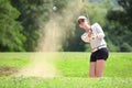 Asian woman golfer hitting a bunker shot Royalty Free Stock Photo