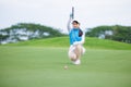 Asian woman golfer sit check line for putting golf ball on green grass Royalty Free Stock Photo
