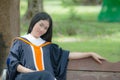 Asian woman in Graduate dress on bench Royalty Free Stock Photo