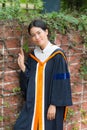 Asian woman in Graduate dress on brick wall Royalty Free Stock Photo