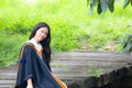 Asian woman in Graduate dress on bridge Royalty Free Stock Photo