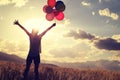 Asian woman on grassland with colored balloons