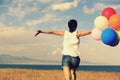 asian woman on grassland with colored balloons