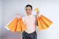 Asian woman guilty worried nervous holding more shopping bags and credit card isolated over background