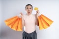 Asian woman guilty worried nervous holding more shopping bags and credit card isolated over background