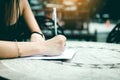 Asian woman hand checking shopping list on desk at outside outlet mall Royalty Free Stock Photo