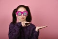 Asian woman hand finger point presenting product for mock-up advertising, Happiness girl wearing funny glasses. Royalty Free Stock Photo