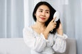 Asian woman hand holding comb brushing her beautiful long black and shiny hair with happy and smiling face Royalty Free Stock Photo