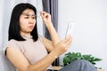 Asian woman hand holding  eyeglasses having problem with farsighted trying to read text on smart phone with eye sight blurred Royalty Free Stock Photo