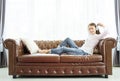 Asian women are happily sitting on the leather sofa in the living room Royalty Free Stock Photo