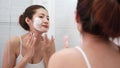 Asian woman happy cleanses the skin with foam in bathroom