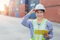 Asian woman happy dock worker control loading containers cargo at shipyard. Marine and carrier staff manager employee. cargo