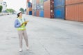 Asian woman happy dock worker control loading containers cargo at shipyard. Marine and carrier staff manager employee. cargo