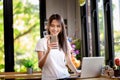 Asian woman or a happy student smiles on a desk with a computer Royalty Free Stock Photo