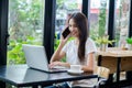 Asian woman or a happy student smiles on a desk with a computer Royalty Free Stock Photo