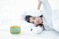 Asian woman happy waking up and turning off the alarm clock having a good day Royalty Free Stock Photo