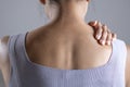 Asian woman has shoulder pain. Female holding painful shoulder with another hand. People with body-muscles problem