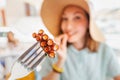 Asian woman in hat eating delicious grilled octopus in seafood restaurant. Delicacy and healthy gourmet cuisine