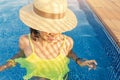 Asian Woman in hat nejoying vacation in swimming pool on the roof Royalty Free Stock Photo