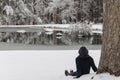 Asian woman in hat sitting in snow