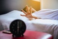 Asian woman hates getting stressed waking up early,Female stretching her hand to ringing alarm to turn off alarm clock