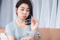 Asian woman have blur vision with eyeglasses try to read mobile phone screen Royalty Free Stock Photo