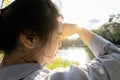 Asian woman have conjunctivitis,cataract,young female covering face by hand of bright sun in outdoor on sunny day,feel dizzy,risk