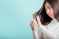 Asian woman have damaged and broken hair, loss hair, dry problem on blue background studio shot