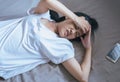 Asian woman have a headache severe on bed after wake up