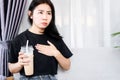 Asian woman have problem with heart beats faster after drinking coffee, heart palpitations caused by caffeine concept