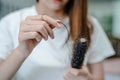 Asian woman have problem with long hair loss attach to comb brush Royalty Free Stock Photo