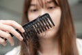 Asian woman have problem with long hair loss attach to comb brush Royalty Free Stock Photo