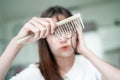 Asian woman have problem with long hair loss attach to comb brush Royalty Free Stock Photo