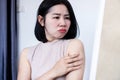 Asian woman have problem with upper arm fat checking extra skin in a mirror Royalty Free Stock Photo