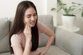 Asian women have toothache pain while sitting on the sofa at home, Asia of girl on the face expression. Concept toothache and Royalty Free Stock Photo