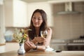 An Asian woman having a drink in kitchen