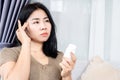 Asian woman having headache hand holding a bottle of medicine