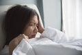 Asian woman having headache on her bed. Migraine. Illness, disease concept. Royalty Free Stock Photo